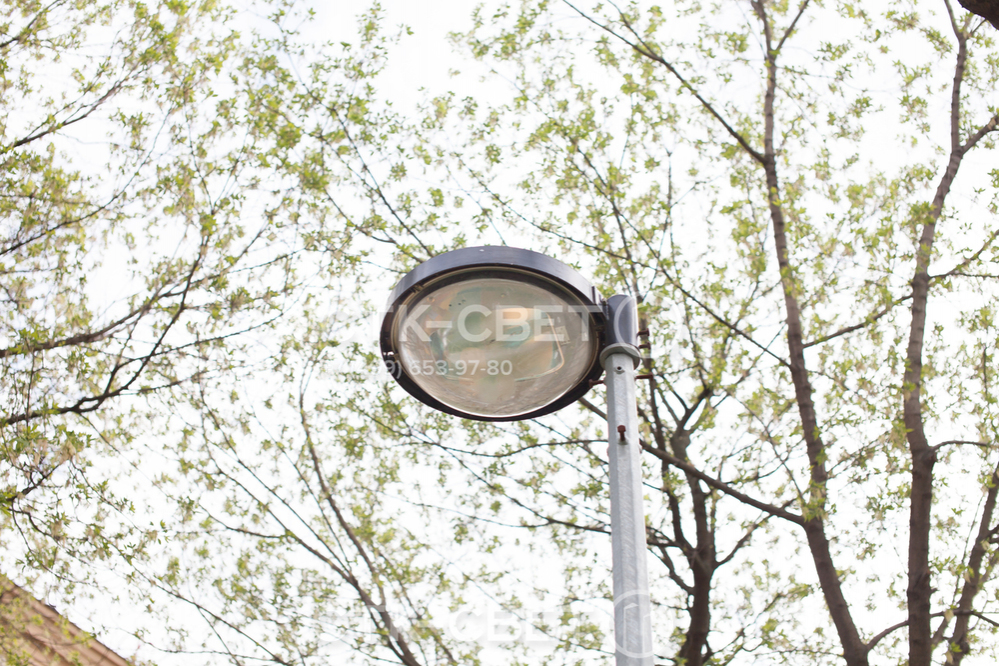 На фото изображена граненая парковая опора со светильником, который закреплен прямо на оголовке. Такой вариант используется в случае, когда нужно осветить ограниченное пространство и расположить световое пятно рядом со стволом.
